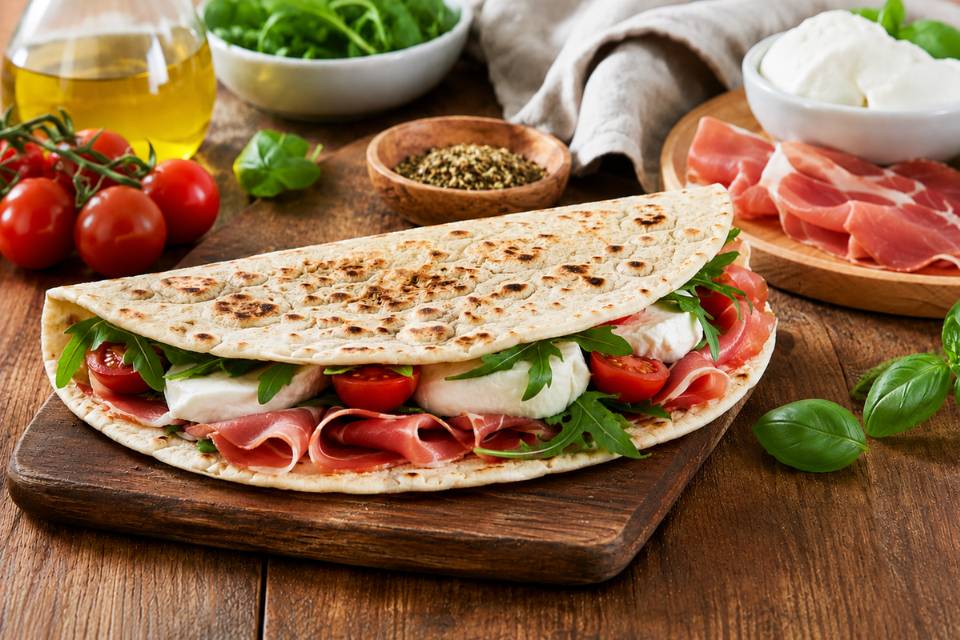 Piadina estiva farcita con ingredienti freschi preparata su una tavola estiva.